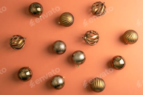 Preview: Golden Christmas baubles arranged on warm orange background. Pattern, top view