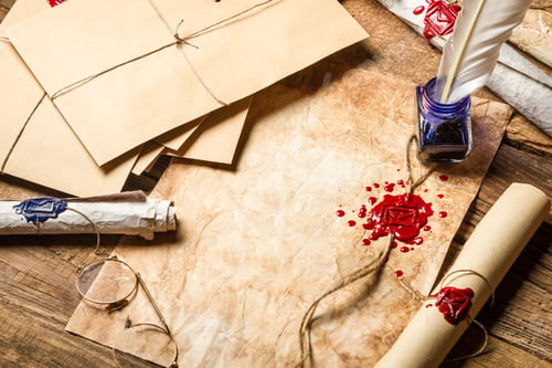 Preview: Old rolls of paper, glasses and blue ink in the inkwell as vintage background