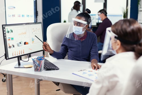 Preview: African businesswoman analysing colorful graph at office