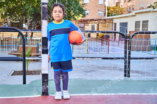 Preview: latin girl goalkeeper football player on a soccer goal with football ball