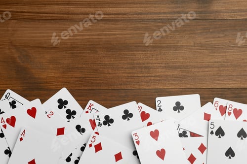 Preview: Playing cards on wooden table, flat lay. Space for text