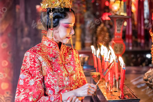 Preview: Woman traditional dress in Chinese shrine light up candle joss stick pray in temple