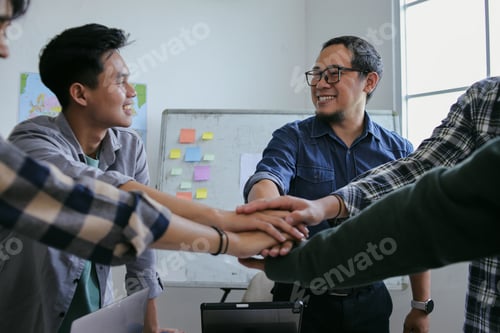 Preview: Smiling Team Stacking Hands In Show Of Unity And Collaboration