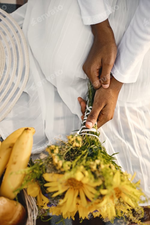 Preview: Cropped portrait of hands of elegant african american woman with yellow flowers