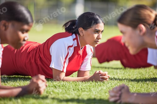 Preview: Women soccer players in a team doing the plank fitness exercise in training together on a practice