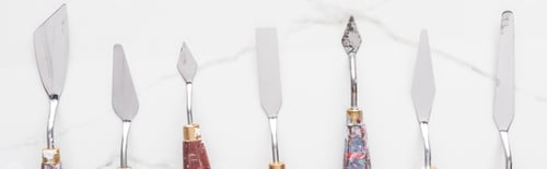 Preview: flat lay with metal spatulas for drawing on marble white surface, panoramic shot