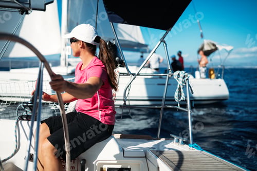 Preview: Happy strong woman sailing with her boat