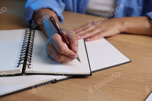 Preview: Student preparing for exam at wooden desk indoors, closeup