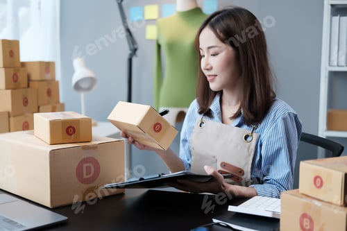 Preview: Startup SME small business entrepreneur SME or freelance Asian woman using a laptop with box