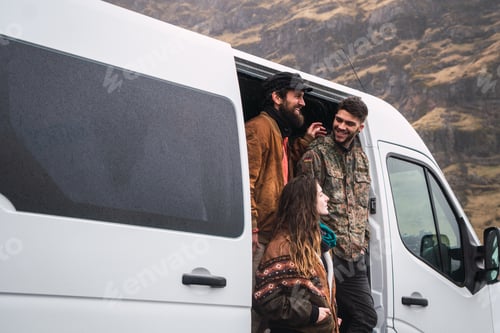 Preview: Laughing friends with van in nature