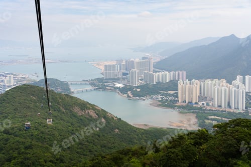 Preview: a mountain side view with city in the background with a gondola ride