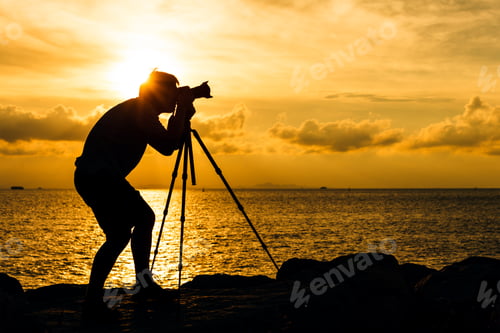 Preview: Silhouette of man taking photo with tripod