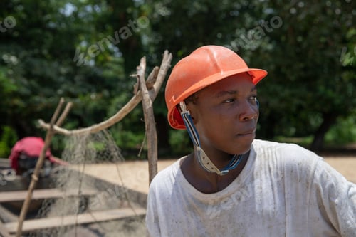 Preview: Portrait of a young African fisherman wearing protective helmet and looking around.