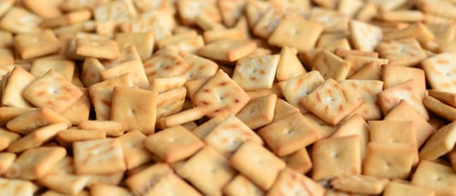 Preview: A lot of small cookies are square shaped. A pattern of a yellow salt cracker