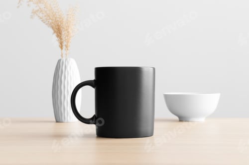 Preview: Black mug mockup with a dry flower decoration on the wooden table.