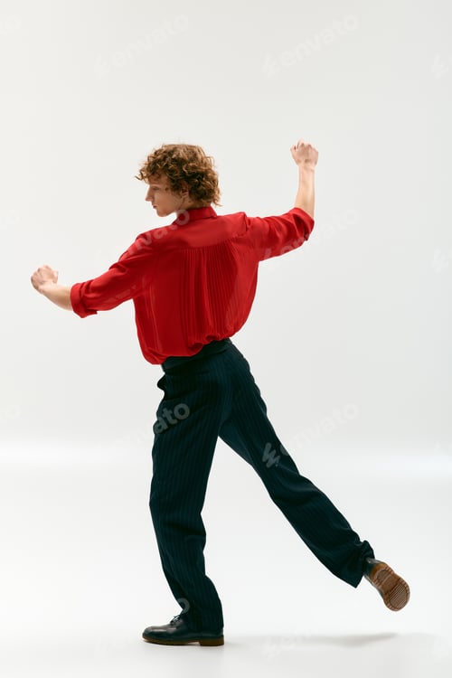 Preview: Elegant young man showcases stylish red shirt in a modern studio setting