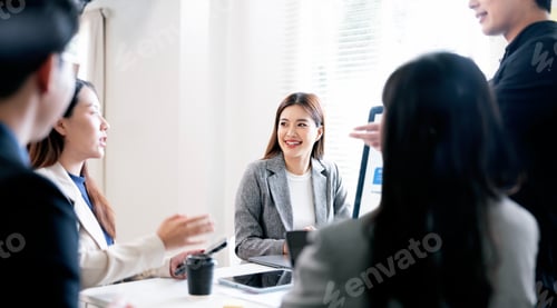 Preview: Smiling businesswoman engaging in a positive team discussion during a corporate meeting