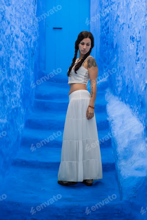 Preview: Young woman looking on blue wall
