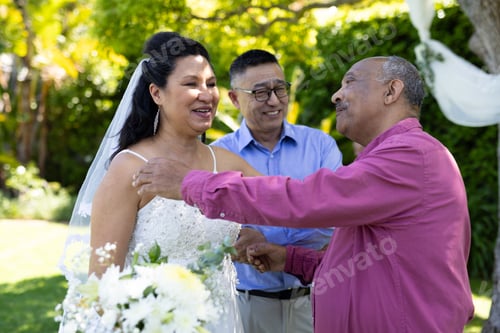 Preview: Greeting guests, bride in white dress smiling at outdoor senior wedding ceremony