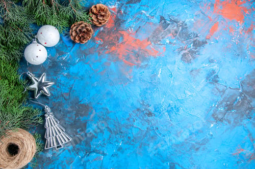 Preview: top view pine tree branches pinecones xmas tree balls straw thread on blue-red background with free