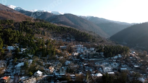 Preview: Aerial view of a village located by the forested mountains. Footage. Ecological place for living.