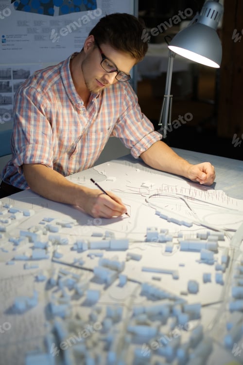 Preview: Young architect working on drawing table in architect studio.