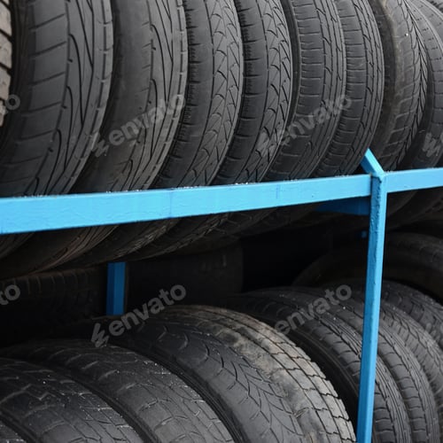 Preview: Rack with variety of car tires in automobile store. Many black tires. Tire stack background