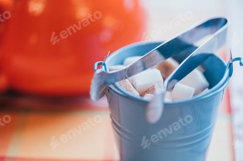 Preview: close-up view of small decorative bucket with sugar and tongs on table top