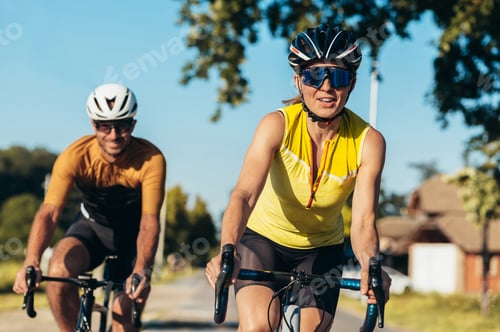 Preview: Couple riding bicycles outside of the city and wearing helmets and sunglasses