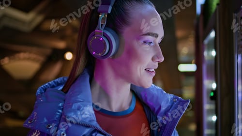 Preview: Teenager headphones smiling camera in night subway closeup. Portrait of woman