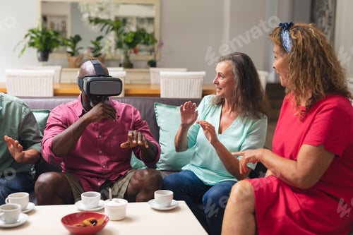 Preview: Multiracial senior women and man with male friend using vr headset at home