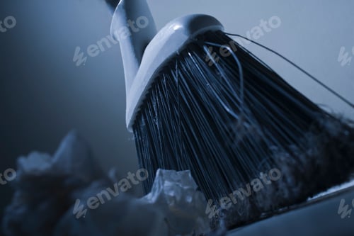 Preview: Cropped view of broom sweeping up rubbish