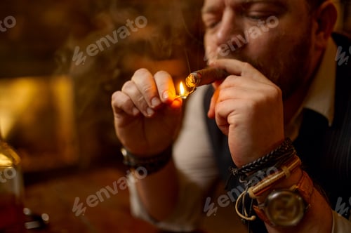 Preview: Portrait of bearded man lights cigar with a match