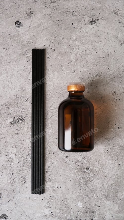 Preview: Aromatic reed diffuser bottle with black sticks on a dark marble background.
