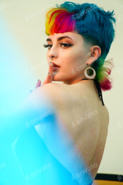 Preview: Female professional model with vibrant multi-colored hair is striking a confident pose for camera