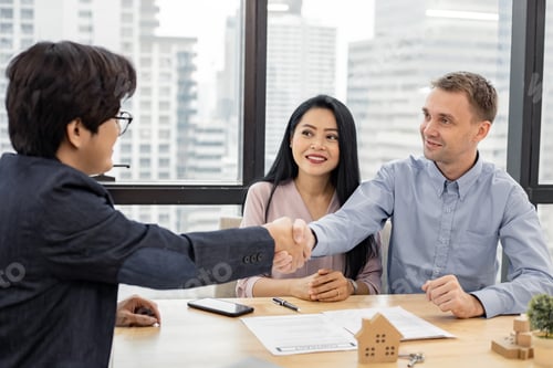 Preview: Couple shaking hands as successful agreement in transaction contract of house with broker.