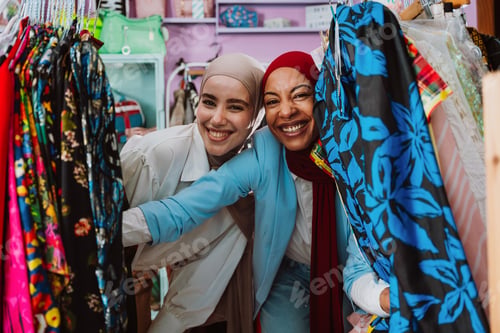 Preview: women friends smiling shopping in clothing store