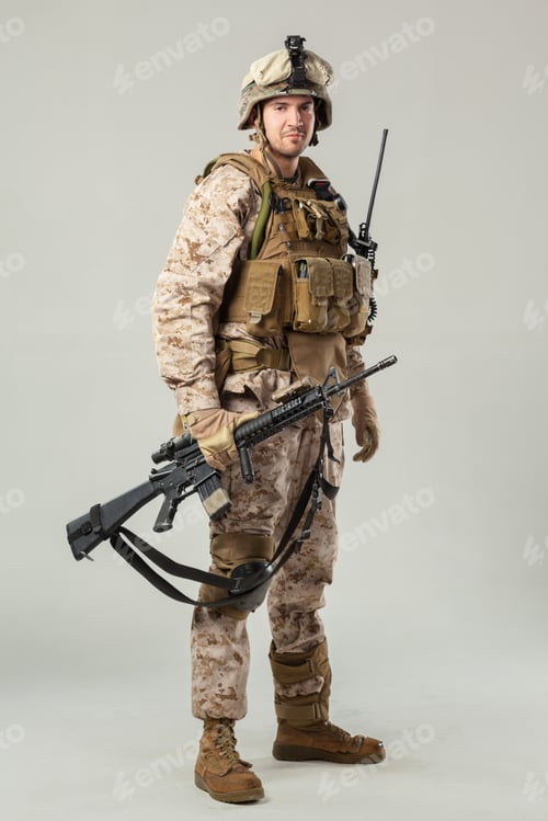 Preview: Soldier in military uniform stands with weapon ready for action in a neutral setting