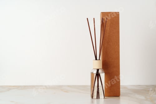 Preview: Reed Diffuser Bottle and Cardboard Box on White Marble Surface