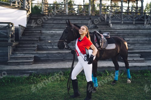Preview: Horsewoman with stallion standing near tribunes and having fun