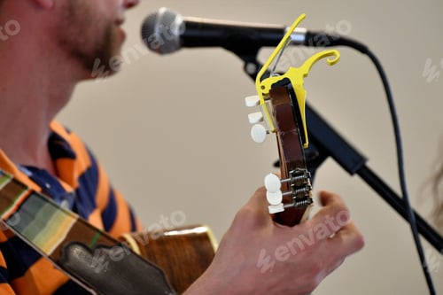 Preview: Playing his guitar while singing. Performing music live on stage. musical instrument.
