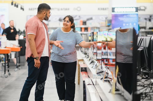 Preview: Beautiful couple buying consumer tech products in modern home appliances store.