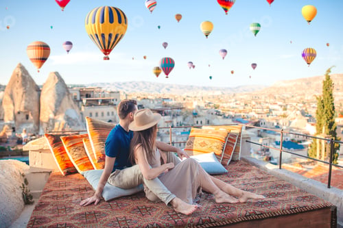 Preview: Happy young couple during sunrise watching hot air balloons in Cappadocia, Turkey
