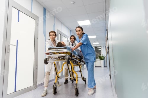 Preview: Worried doctors and nurse transporting unconscious patient on gurney