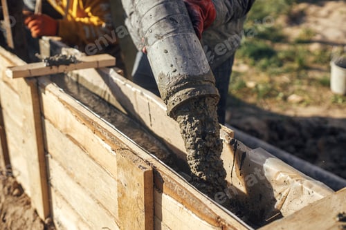 Preview: Workers pouring concrete in formwork for foundation
