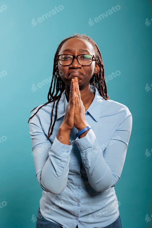 Preview: Religious and spiritual young person having palms together while praying in hope and faith for world