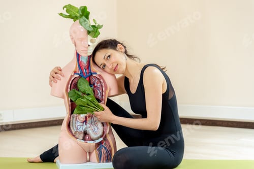 Preview: A Yoga Coach Sits Next To A Medical Dummy