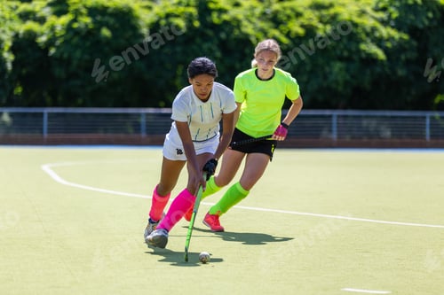 Visualização: Duas jogadoras de hóquei em campo lutando pela bola no campo no ataque