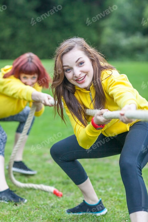 Preview: Young women playing tug of war on field