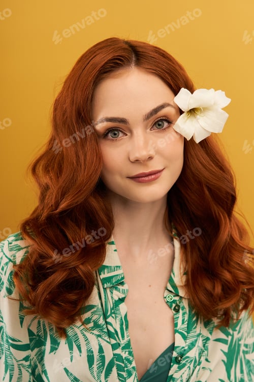 Preview: Captivating woman with flowing hair and a flower in her hair stands against a vibrant background